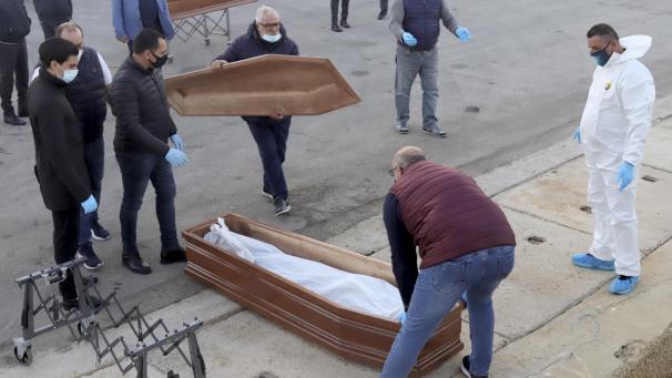 <p>14.11.2020, Italien, Trapani: Ein in einem Leichensack verstauter Leichnam eines Geflüchteten wird in einen Sarg gelegt. Der Tote war zuvor von einem Schiff der spanischen Hilfsorganisation Open Arms im Hafen von Trapani an Land gebracht worden, nachdem das Schiff mit rund 250 aus Seenot geretteten Menschen an Bord die italienische Küste erreicht hatte. Die Geflüchteten seien bei insgesamt drei Rettungsaktionen am 10. und 11.11.2020 aufgenommen worden, wobei fünf Menschen nur noch tot geborgen worden konnten.</p>