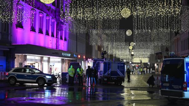 <p>Ein Polizeifahrzeug am Abend steht in der weihnachtlich beleuchteten Simeonstraße in Trier: Am Nachmittag war ein Mann mit einem Auto durch die Fußgängerzone gefahren und hat dabei Menschen verletzt und getötet.</p>