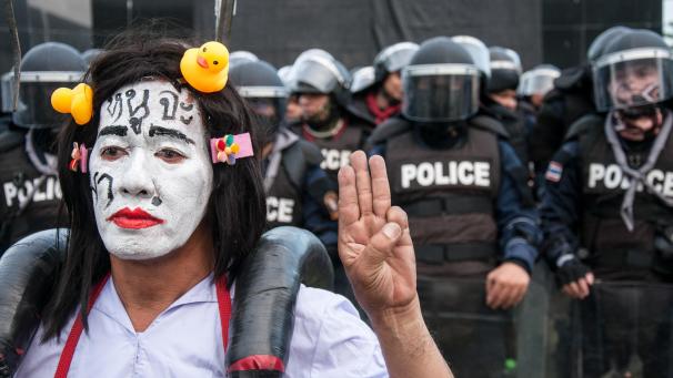 <p>Ein geschminkter Teilnehmer einer regierungskritischen Demonstration hebt als Zeichen des Widerstands vor einer Polizeiabsperrung die Hand zum drei-Finger-Gruß. Tausende pro-demokratische Demonstranten verlangen den Rücktritt des Thailändischen Premierministers und eine Reform der Monarchie.</p>