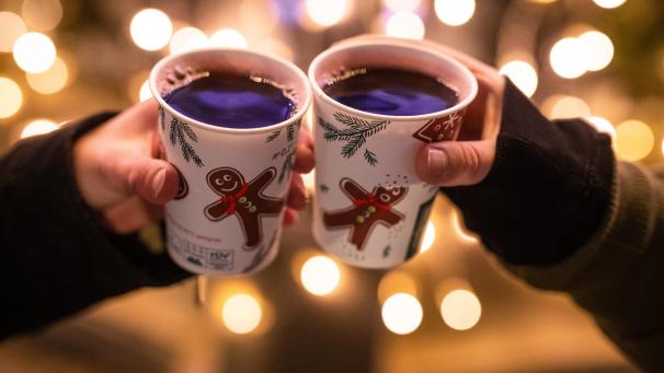 <p>Zwei Frauen stoßen während der Corona-Pandemie mit Glühwein gefüllten Bechern an.</p>