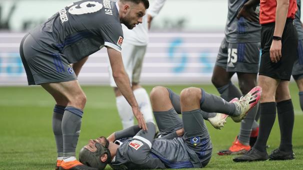<p>Der Hamburger Klaus Gjasula liegt verletzt am Boden, links steht sein Mannschaftskamerad Manuel Wintzheimer.</p>
