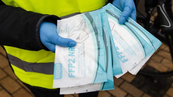 <p>Eine Frau hält FFP2-Masken in den Händen, die sie für sich und ihren Mann in einer Apotheke bekommen hat.</p>