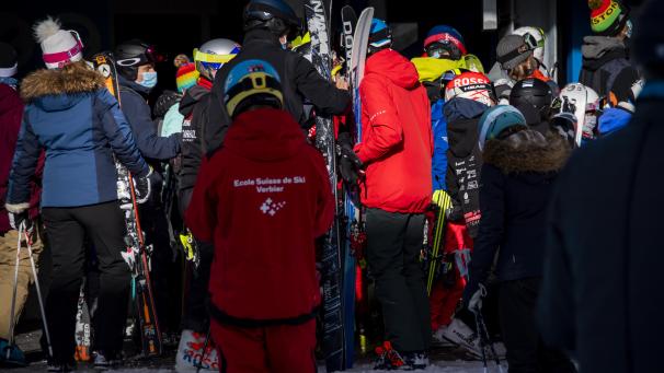 <p>Skifahrer mit Masken stehen Schlange, nachdem die Gondelbahn im Walliser Skigebiet während der Corona-Pandemie kurz angehalten wurde.</p>