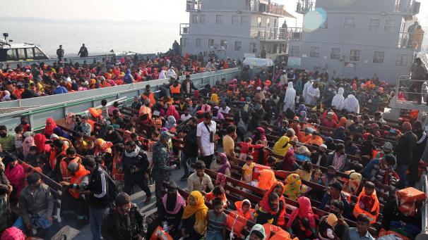 <p>Rohingya-Flüchtlinge betreten ein Marineschiff, um zu einer Insel im Golf von Bengalen transportiert zu werden. Die Geflüchteten wurden trotz Kritik von Menschenrechtsgruppen auf die Insel umgesiedelt.</p>