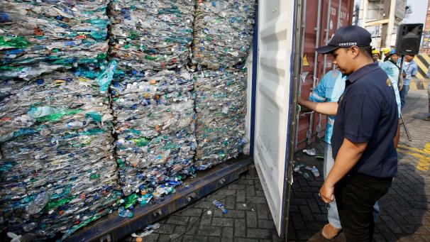 <p>Ein Zollbeamter verschließt einen Container mit Plastikmüll am Hafen von Tanjung Priok.</p>