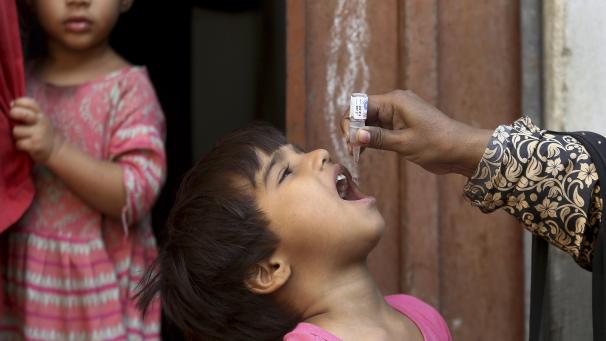 <p>Ein Mitarbeiterin des Gesundheitswesens verabreicht einem Kind in Pakistan einen Polioimpfstoff.</p>