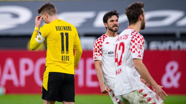 <p>Dortmunds Marco Reus (l-r) geht nach seinen verschossenen Elfmeter an den Mainzern Danny Latza und Alexander Hack vorbei.</p>