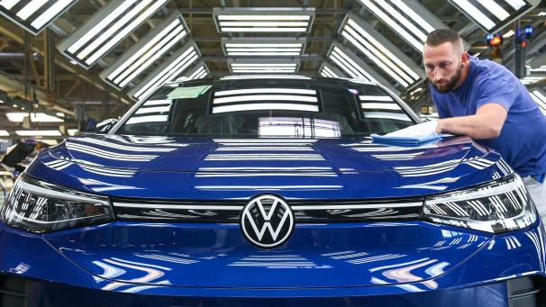 <p>Ein Mitarbeiter im Volkswagenwerk in Zwickau kontrolliert im sogenannten Finish einen VW ID.4 im Lichttunnel.</p>