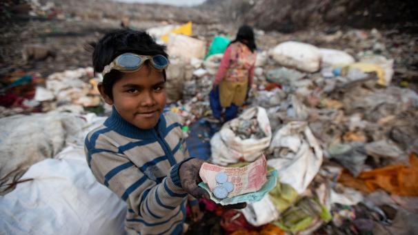 <p>Der zehnjährige Shekh Zahid zeigt das Geld, das er nach dem Verkauf der verwertbaren Gegenstände beim Müllsammeln auf der Bhalswa-Mülldeponie verdient hat.</p>