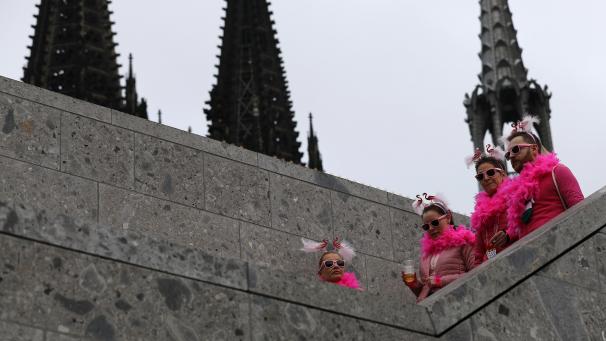 <p>Karnevalistinnen und Karnevalisten feiern vor dem Kölner Dom. Die Weiberfastnacht leitet traditionell den Beginn des Straßenkarnevals ein. In diesem Jahr ist alles anders.</p>