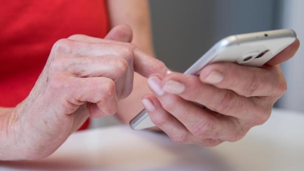 <p>Eine ältere Dame bedient das Touch-Displays eines Smartphones.</p>