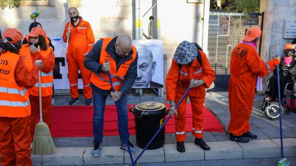 <p>Als Gefangene verkleidete Aktivisten führen während einer Demonstration, auf der der Rücktritt des israelischen Premierministers Netanjahu gefordert wird, eine fingierte Aufräumaktion durch, um „die Straßen von Korruption zu säubern“. Netanjahu ist am Montag vor dem Jerusalemer Bezirksgericht erschienen, um formell auf die Anklage im Korruptionsprozess gegen ihn zu antworten.</p>