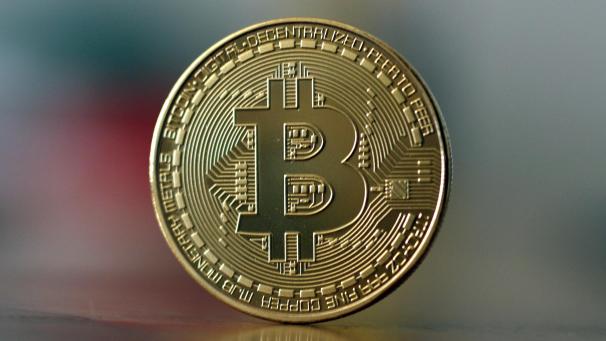 <p>Eine Bitcoin Münze steht auf einem Tisch. Die Digitalwährung Bitcoin ist so wertvoll wie nie.</p>