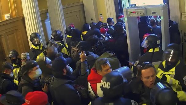 <p>Sicherheitskräfte bemühen sich die Eindringlinge im Kapitol zurückzuhalten. Diese Videoaufnahmen des Angriffs auf das US-Kapitol haben die Ankläger im Amtsenthebungsverfahren gegen Ex-Präsident Trump im Senat gezeigt, um ihre Vorwürfe zu untermauern. Es reichte aber nicht zur Verurteilung.</p>