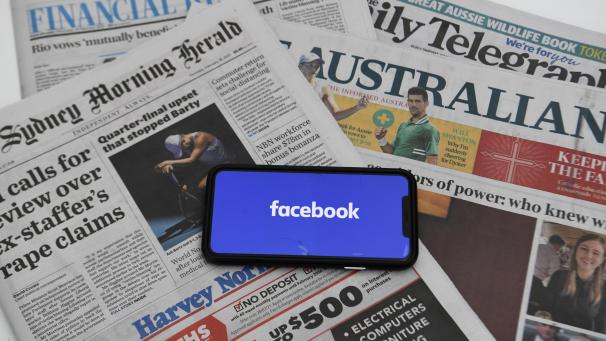 <p>Ein Illustrationsbild zeigt das „Facebook“-Logo auf dem Bildschirm eines Smartphones, das auf australischen Zeitungen liegt.</p>