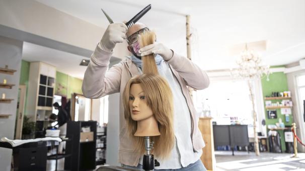 <p>Haarschneider Marco Trapani steht in seinem Salon und übt seine Fingerfertigkeit an einer speziellen Puppe, die in der Regel seine Auszubildenden zum Erlernen neuer Frisuren benutzen. Trapani eröffnet seinen Salon nach der Corona-Pause zu frühest möglichen Termin, am 1. März um 0:01 Uhr.</p>
