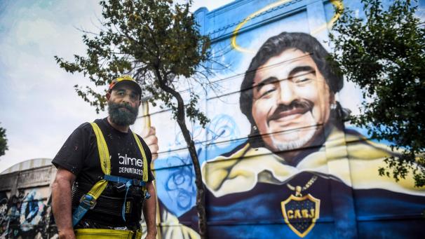 <p>Alfredo Segatori steht vor seinem Wandgemälde im Viertel La Boca zu Ehren des „Goldjungen“ Maradona.</p>