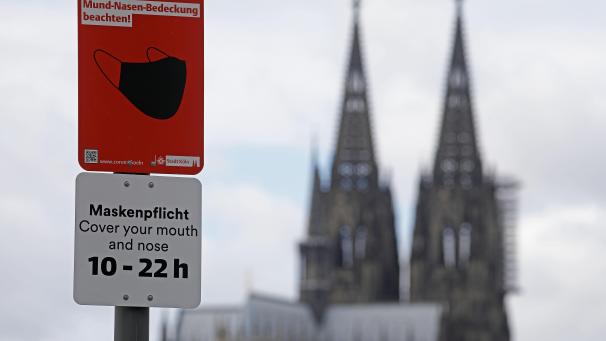<p>Ein Schild, das auf die Maskenpflicht hinweist, steht am Rheinufer vor dem Dom.</p>