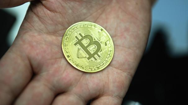 <p>Ein Mann hält eine nachgemachte Münze mit dem Bitcoin-Logo in den Händen.</p>