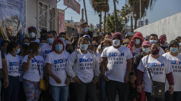 <p>«Biden, please let us in» (Biden, lassen Sie uns bitte rein), steht auf Englisch auf den T-Shirts einer Gruppe Migranten unterschiedlicher Herkunft, die sich auf den Weg zum internationalen Grenzübergang „El Chaparral“ machte. Die Migranten baten die neue US-Regierung um Asylrecht.</p>