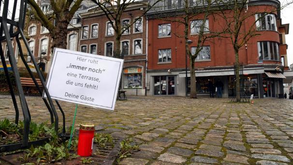 <p>Auf dem Eupener Marktplatz steht eine Grabkerze anstelle von Bistrotischen.</p>