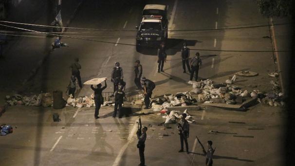 <p>Bewaffnete Polizisten entfernen eine Straßenblockade, die von Demonstranten errichtet wurde. In vielen Städten gibt es weiterhin Proteste gegen die Militär-Junta im Land.</p>