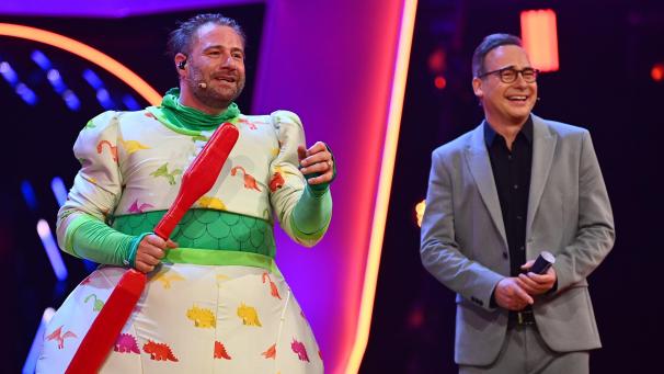 <p>Der Sänger Sasha (l.) jubelt im Finale der ProSieben-Show „The Masked Singer“ im Kostüm des Dinos neben Moderator Matthias Opdenhövel über seinen Sieg.</p>