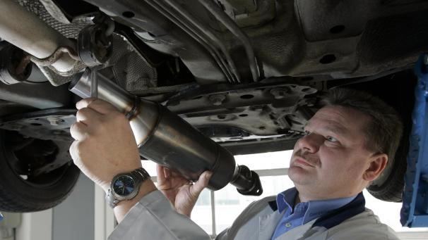 <p>Ein Kfz-Mechaniker baut einen neuen Rußpartikelfilter ein.</p>