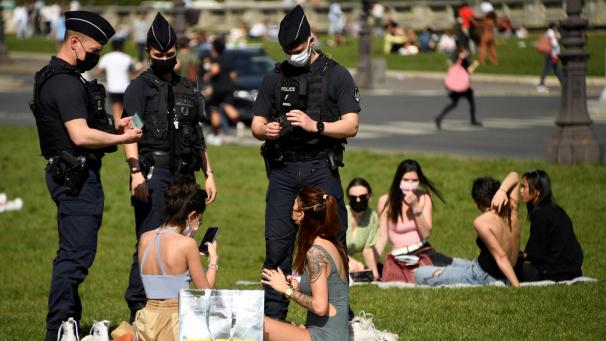 <p>Polizisten kontrollieren am 31. März in Paris Personen, die es sich vor dem Hôtel des Invalides gemütlich gemacht hatten.</p>