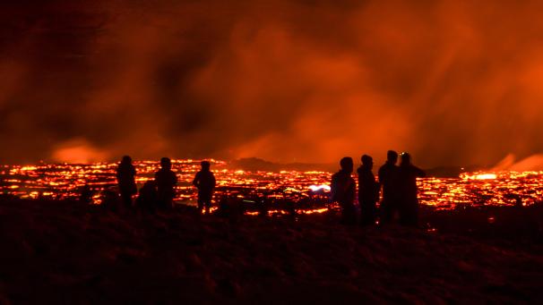 <p>Menschen beobachten die Lava des Vulkans nach dessen Ausbruch auf der Halbinsel Reykjanes im Südwesten Islands</p>