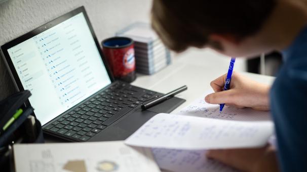<p>Ein Schüler sitzt in seinem Zimmer am Schreibtisch und erledigt Aufgaben im Rahmen des Homeschoolings.</p>