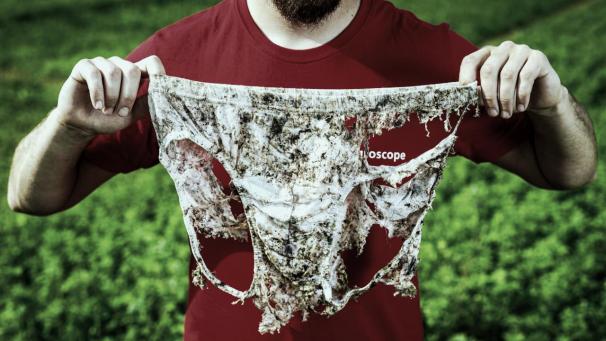 <p>Ein Mann hält eine Unterhose, nachdem sie ausgegraben wurde. In der Schweiz soll landesweit weiße Unterwäsche in der Erde verschwinden.</p>