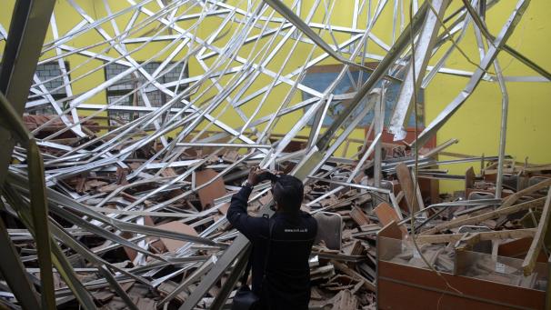 <p>Ein lokaler Journalist filmt den Schaden an einem Klassenzimmer in einer Schule.</p>