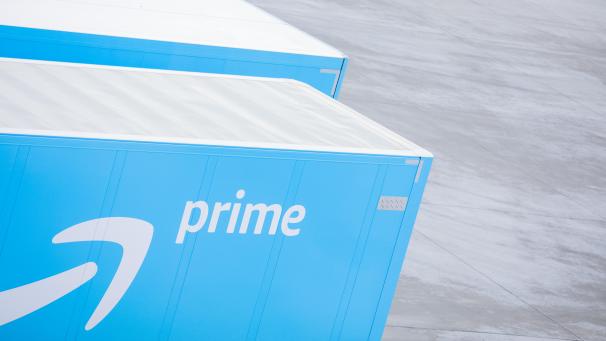 <p>Lkw mit dem Logo von Amazon Prime stehen vor einem Logistikzentrum des Versandhändlers Amazon.</p>