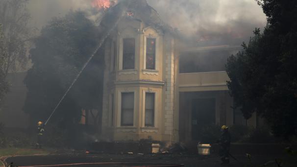 <p>Feuerwehrleute löschen ein brennendes Gebäude an der Universität von Kapstadt.</p>