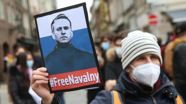 <p>Ein Demonstrant hält ein Plakat mit dem Abbild des russischen Oppositionsführers Nawalny mit dem Schriftzug „#FreeNavalny“</p>