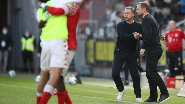 <p>Münchens Trainer Hans-Dieter „Hansi“ Flick (links) gratuliert Mainz' Trainer Bo Svensson zum Sieg seiner Mannschaft.</p>