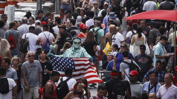 <p>Unzählige Menschen, darunter ein Verkleidungskünstler mit US-Flagge, gehen über den Times Square. Alle zehn Jahre steht in den USA eine Volkszählung an, 2020 war es wieder soweit.</p>