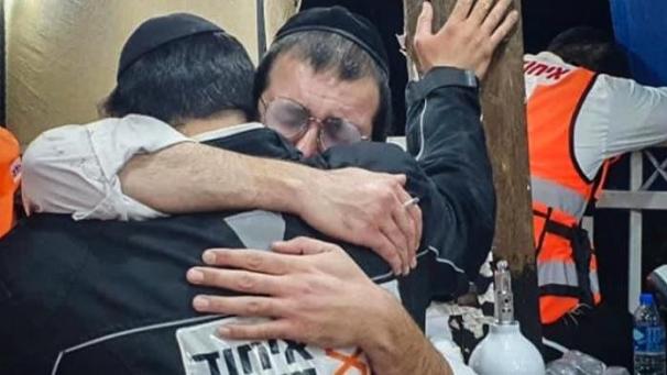 <p>Männer trösten sich gegenseitig an der jüdisch-orthodoxen Pilgerstätte auf dem Berg Meron.</p>