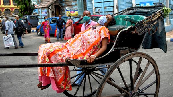 <p>Eine an Covid-19 erkrankte Frau wird auf einer Rikscha zum Kolkata Medical College Hospital gebracht.</p>