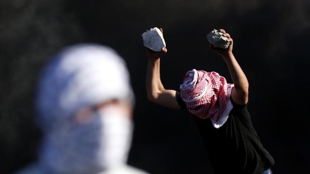 <p>Ein Mann hält Steine, um sie auf israelische Soldaten zu werfen während Zusammenstößen mit israelischen Sicherheitskräften am Hawara-Kontrollpunkt.</p>