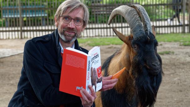 <p>Autor Johannes Schröer am Mittwoch bei der Vorstellung des Buches „Patron Hennes“ mit Hennes IX, dem Maskottchen des Fußball Bundesligisten 1. FC Köln, in einem Gehege im Zoo.</p>
