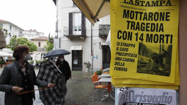 <p>Menschen stehen vor einem Zeitungskiosk, an dem eine Zeitung mit der Schlagzeile „Mottarone-Tragödie mit 14 Toten“ ausgehängt ist.</p>