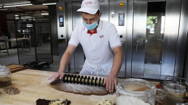 <p>Ein Mitarbeiter des Herstellers Nobis schneidet Lebkuchenteig. Wer jetzt an die Adventszeit denkt, ist jedenfalls in Aachen verkehrt.</p>