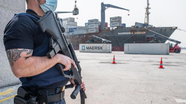 <p>Ein bewaffneter Zollbeamter an einem Containerdock im Hafen von Antwerpen.</p>