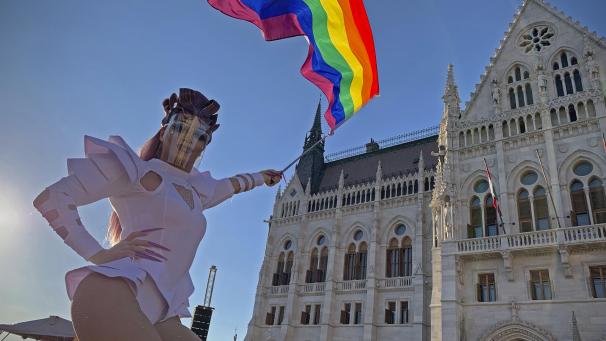 <p>Eine Drag Queen schwenkt eine Regenbogenfahne auf einer LGBT-Rechte-Demonstration vor dem ungarischen Parlament. Tausende Menschen hatten dort zuletzt immer wieder gegen das geplante Gesetz demonstriert, das die Informationsrechte und den Schutz von homosexuellen und transsexuellen Jugendlichen einschränken soll.</p>