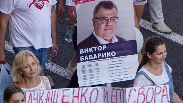 <p>Menschen demonstrierten im August 2020 in Minsk gegen Machthaber Lukschenko und trugen dabei ein Transparent mit dem Foto von Viktor Babariko, der bei der Präsidentenwahl gegen Lukaschenko antreten wollte.</p>