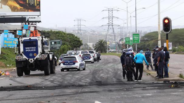 <p>Polizisten patrouillieren auf einer Straße, nachdem Demonstranten brennende Barrikaden errichtet hatten.</p>