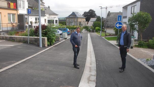 <p>Bürgermeister Herbert Grommes (rechts) und Bauschöffe René Hoffmann begutachten die sanierte Wohnstraße Ascheider Wall im Zentrum von St.Vith.</p>