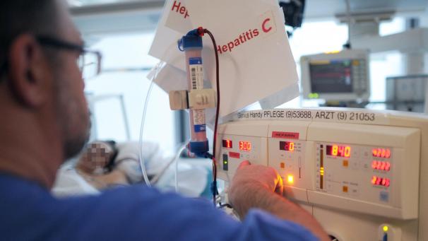 <p>Ein Pfleger kümmert sich auf der Intensivstation um einen Patienten mit Hepatitis C.</p>